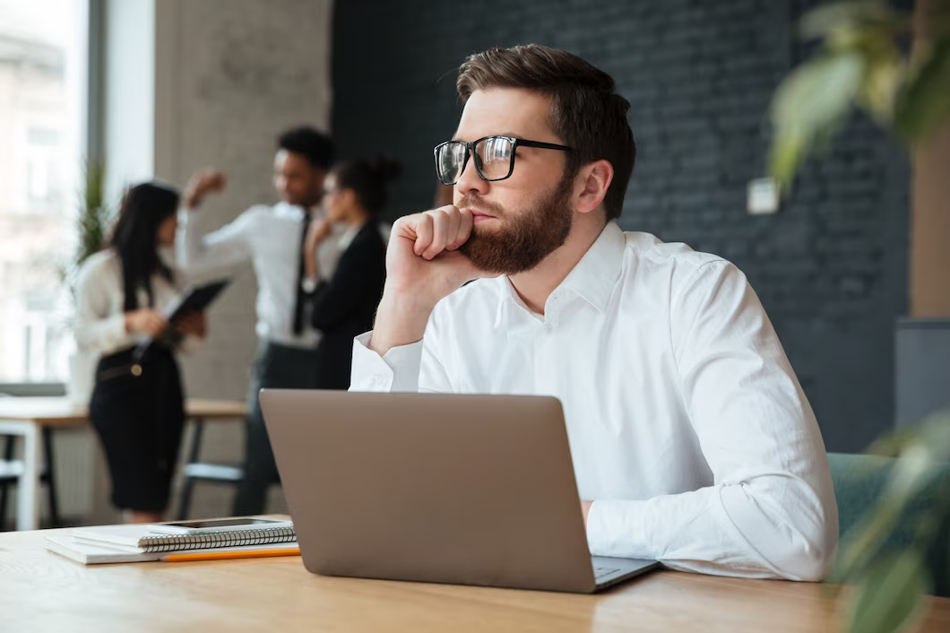 Person Wearing Eyeglasses, Using Laptop, and Gazing into the Distance